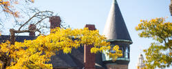 Image of Carr House roofline on campus amid fall foliage