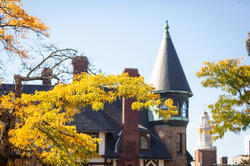 Image of Carr House roofline on campus amid fall foliage