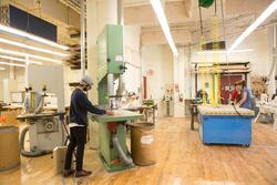 students work at several fabrication stations in a spacious workshop